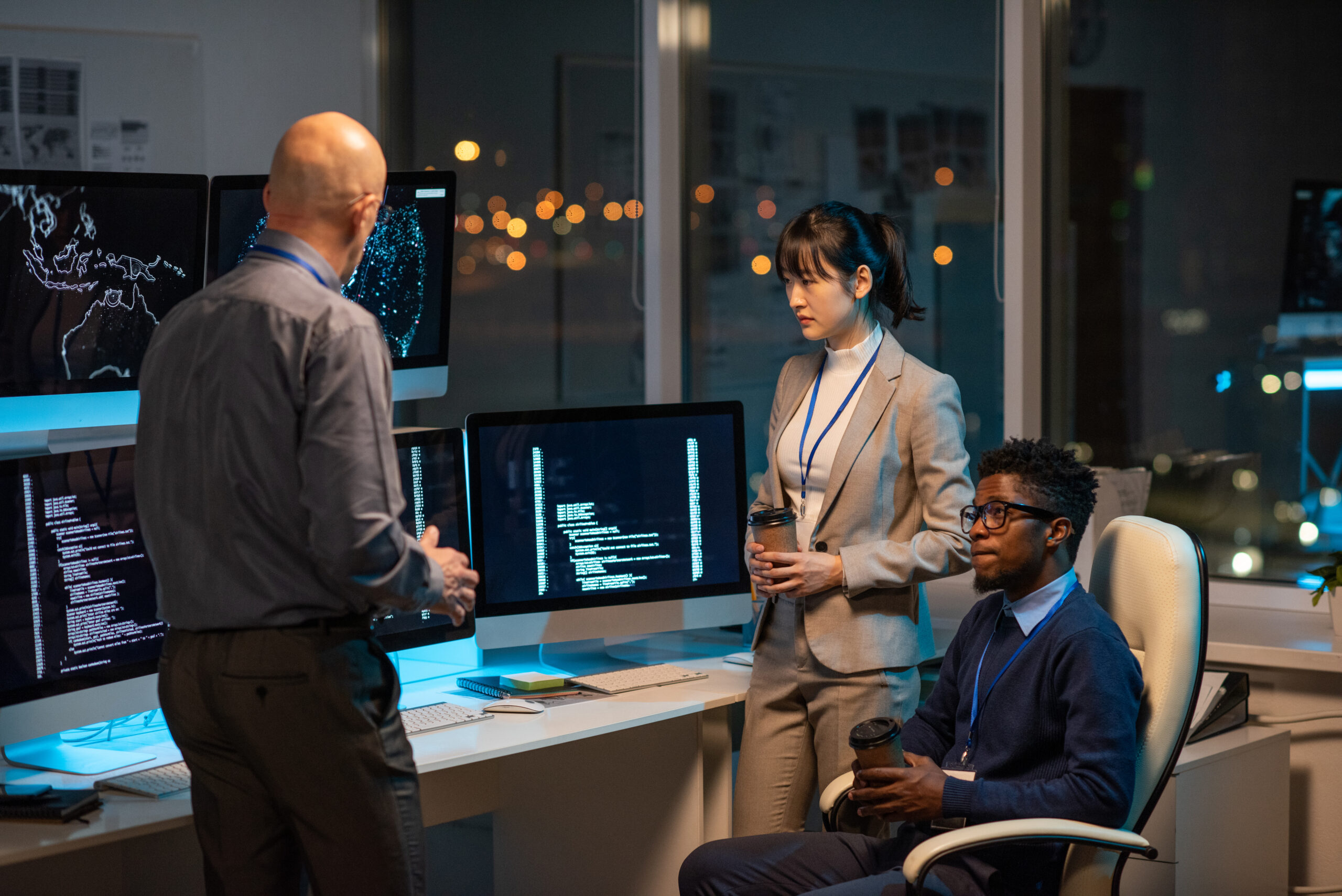 Three professionals in an office discussing business security insights