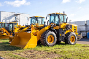 Construction equipment sitting idle outside a construction site. 