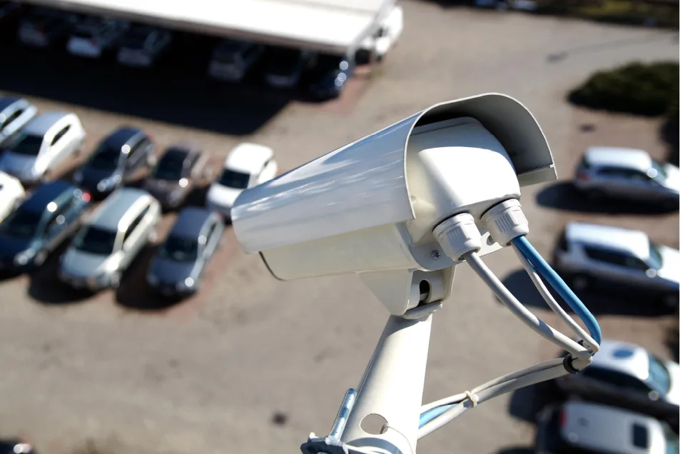 Video surveillance cameras monitoring a car dealership.
