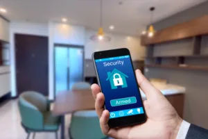 Man using his phone to check in on his security system remotely. The app allows him to arm or diarm his system with the tap of a button.
