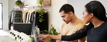 A woman pointing at a man's laptop screen