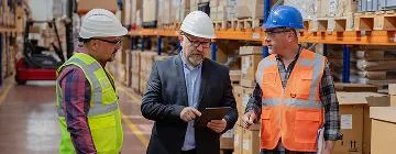 Workers wearing hard hats in a warehouse