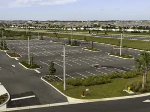 Outdoor remote parking lot with surrounding foiliage that has been trimmed to allow full visibility of lot from every corner.